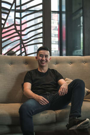 Asian young handsome man sitting in coffee shop, talking and smiling. chinese guy, millennials life,...