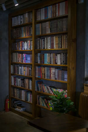 Wooden shelves with books in the cafe. Vintage style in a cafe. Library. High quality photoの写真素材