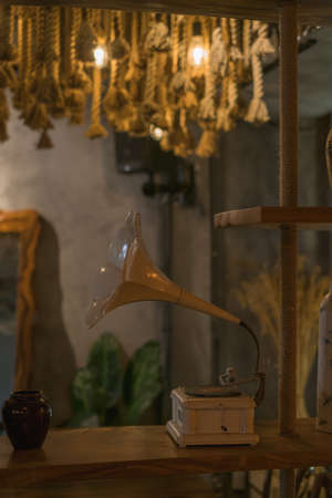 Old music player in a coffee shop. Retro style design Chandeliers made from the rope. Antique items on the wall. Solid wood furniture. Coffee shopの写真素材