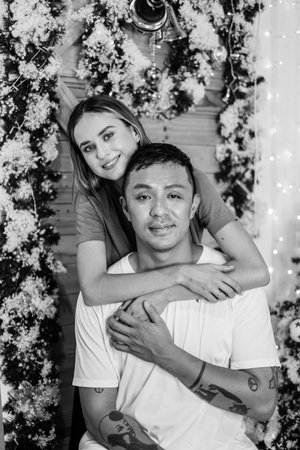 Black and white portrait of lovely couple. New Years photo of happy couple. Cuddling, smiling and looking at camera with copy space.の写真素材