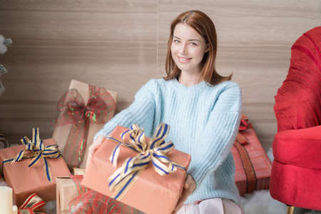 Christmas holiday. New Year portrait of adorable girl sitting near decorated Christmas tree with...