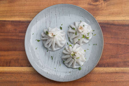 National Georgian cuisine. Khinkali with meat. Khinkali on a plate on wooden background. Top view, close up with copy space. High quality photoの写真素材