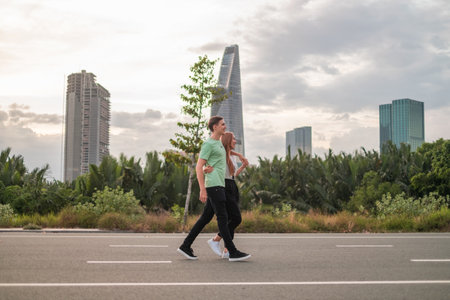 Lovely young couple walking on the street in the big city on the sunset. Boyfriend and girlfriend....