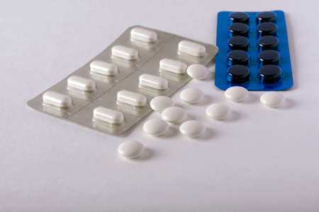 tablets in silver and blue blister,scattered tablets lying on an isolated white backgroundの写真素材