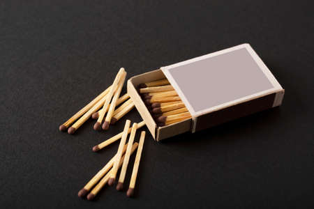 open box of matches, scattered single matches on a black background, macroの写真素材