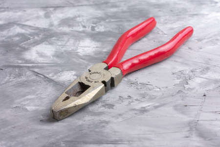 Pliers with red handles on a gray background,macroの写真素材