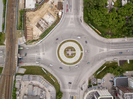 Aerial view of square in the city with roundabout traffic, streets and buildings with green trees. Intersection of two roadsの写真素材