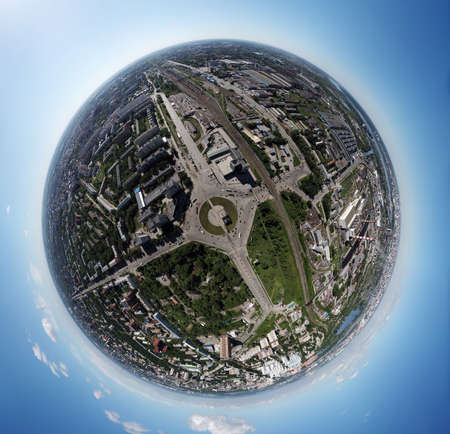 Aerial view of square in the city with roundabout traffic, streets and buildings with green trees. PanoramÐ° 360 degrees planet and blue sky aroundの写真素材