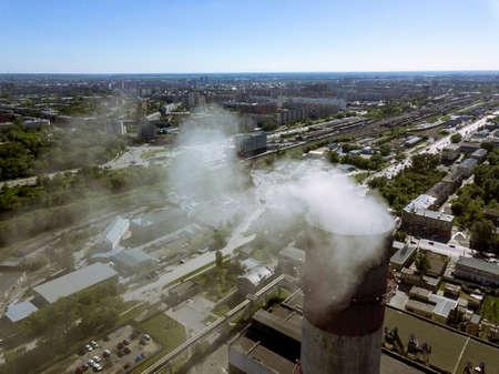 View from the air on the red and white pipe from the plant from which the smoke is coming from the polluting airの写真素材