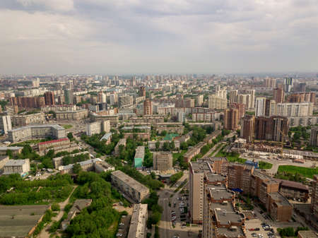 Old and new russian buildings in green area in the city with a lot of cars and roundabout. Russian streets, Novosibirsk.のeditorial素材