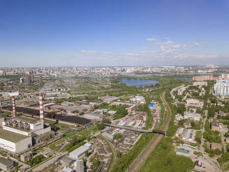 View from the air on old and new russian buildings with lake, plant with smoke and blue sky in the cityの写真素材