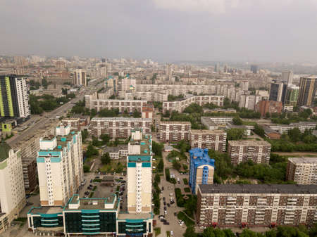 View from the air on a lot of old and new russian buildings in green area in the city with a lot of cars. Russian streets, Novosibirsk.のeditorial素材