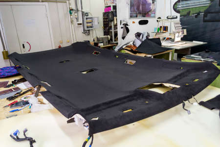 Black ceiling lining removed from the car for tuning and bracing with black soft material on a table...