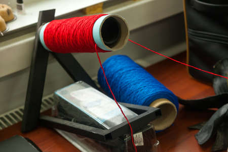 Two big bobbins with large mating colored threads in the studio fot interior design  on the tableの写真素材