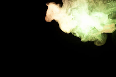 Multicolored smoke from a vape of red and yellow color of the strange mystical form on on a black...