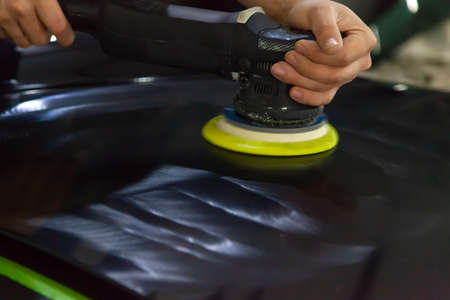 The master in the service station polishes the car body, using a polishing machine, shiny, clean,...