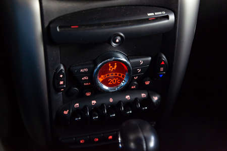 Air conditioning on the dashboard climate control car inside the cabin close-up with red...