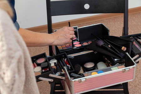 A set of professional cosmetics in the box open close up with content. Makeup artist girl at work,...