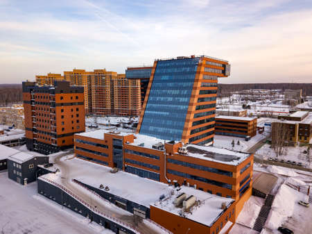 Aerial view of academpark technopark of the Novosibirsk Academic Township - large building with laboratories and innovative projects, technical inventions covered with snow in a winter day with cloudsの写真素材