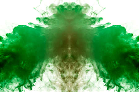 A background of green, red and gray wavy smoke in the shape of a ghost's head or a man of mystical appearance on a white isolated ground. Bright abstract pattern of steam from vape.の写真素材