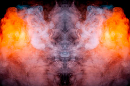 A fiery drawing of evaporating vapus smoke on a black background awe-inspiring a drawn head of a mystical creature in flames of yellow orange and red.の写真素材