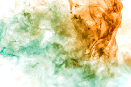 Multicolor, thick smoke, illuminated by colored in green and red light against a white isolated background, welded with clubs and curls, rising from a steam of vape. Wind blowの写真素材