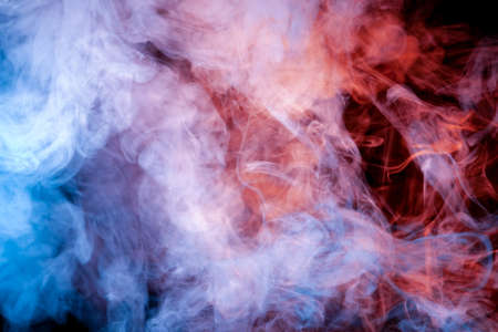 The beautiful color combination of blue, orange, violet and red hues from the substance is smoke, on a black background resembling the Milky Way. T-shirt print.の写真素材