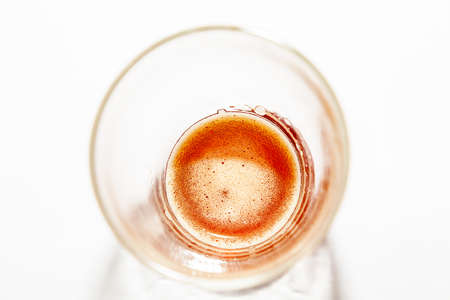 Wheat-colored beer in a glass transparent glass is left on the bottom with a small foam on the surface, the drink absorbs thirst in the summer, is popular at parties.の写真素材