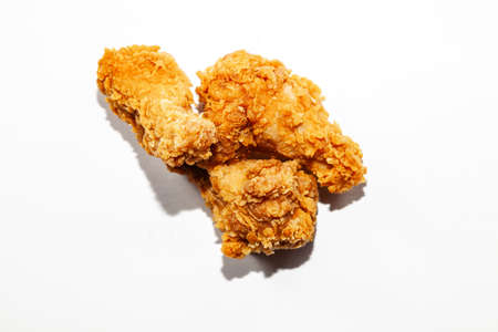 Fried delicious, appetizing chicken wings made from fresh meat in a spicy sauce and breaded are a popular dish in restaurants and fast food are three in number on a white background. Unhealthyの写真素材