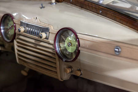 Novosibirsk, Russia - 01.30.2019: Instruments and panel of the old Russian car of the executive class with clock and radio, released in the Soviet Union beige GAZ m-20 pobedaのeditorial素材