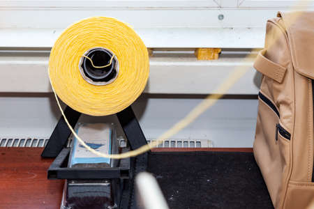 One big yellow bobbin with large mating colored threads in the studio for interior design workshop...