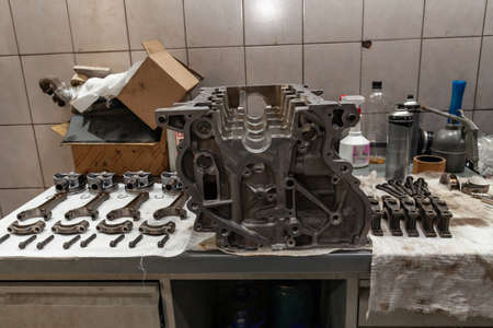Engine connecting rods and pistons used and removed from a four-cylinder engine on a white soft cloth in a vehicle repair workshop. Auto service industry.の写真素材