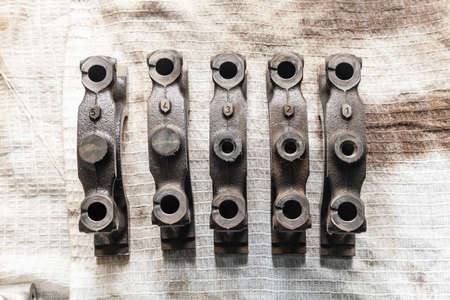 Engine connecting rods and pistons used and removed from a four-cylinder engine on a white soft...