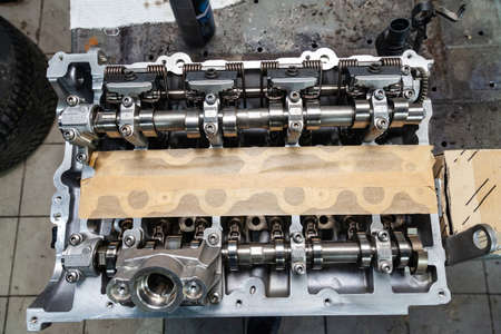 A four-cylinder engine with new camshaft dissembled and removed from car on a workbench in a vehicle...