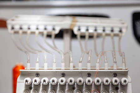 White thread guide in industrial sewing machine for embroidery of paintings and logos with threads...