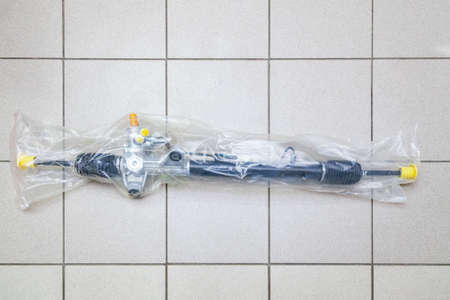 Spare part of the car steering rack new in plastic packaging for turning the wheels close-up on the...