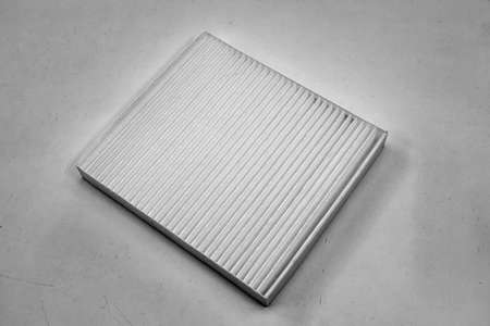Close-up on a car filter for a white engine as a background with vertical stripes. Spare parts for...
