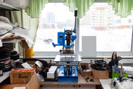 Press machine in the workshop for doing the embossed logo and letters on the leather product that heats the cliche and squeezes the desired image on the materialの写真素材