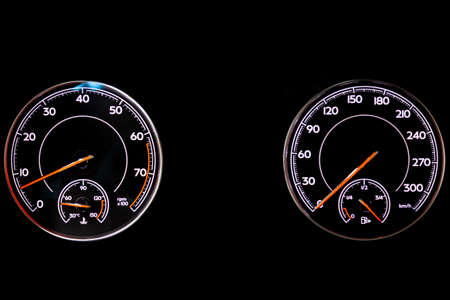 The dashboard of the car is glowing blue with red arrows at night with a speedometer, tachometer and other tools to monitor the condition of the vehicle in modern style on black isolated backgroundの写真素材