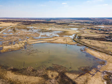Aerial view of a marshland near a highway with an asphalt road during a spring flood, which floods...