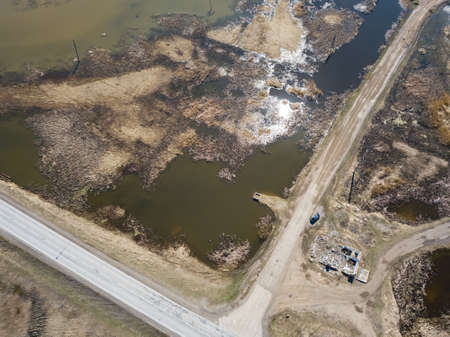 Aerial view of the intersection of asphalt and ground roads in the field far from the big cities on...