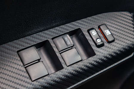 Interior view with drivers door, window buttons and armrest of black and gray interior fabric of the...
