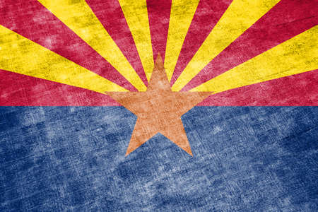 The national flag of the US state Arizona in against a gray textile rag on the day of independence in different colors of blue red and yellow. Political and religious disputes, customs and delivery.の写真素材
