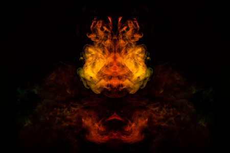 Abstract image of smoke of different green, yellow, orange and red colors in the form of horror in...