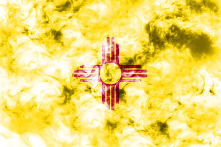 The national flag of the US state New Mexico in against a gray smoke on the day of independence in different colors of blue red and yellow. Political and religious disputes, customs and delivery.の写真素材