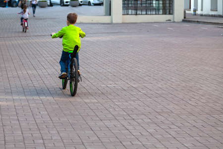 Novosibirsk, Russia - 05.28.2019: Rest in the park in the summer where boy ride bicycle on a clear sunny summer day. Active outdoor recreation in the city.のeditorial素材