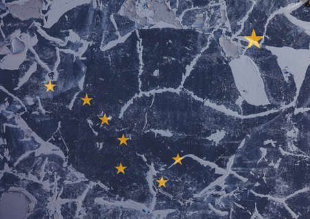 The national flag of the US state Alaska in against a gray wall with cracks and faults on the day of...