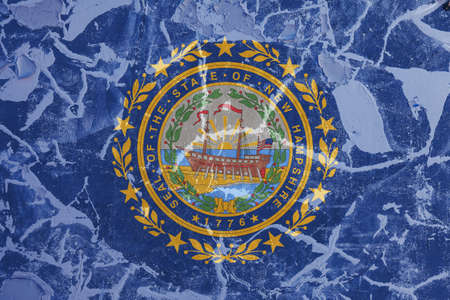 The national flag of the US state New Hampshire in against a gray wall with cracks and faults on the day of independence in blue and yellow. Political and religious disputes, customs and delivery.の写真素材