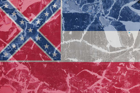 The national flag of the US state Mississippi in against a gray wall with cracks and faults on the day of independence in blue red and white. Political and religious disputes, customs and delivery.の写真素材
