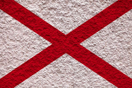 The national flag of the US state Alaska in against a gray wall with stony surface on the day of independence in colors of blue ground and yellow stars. Political and dispute, customs and deliveryの写真素材